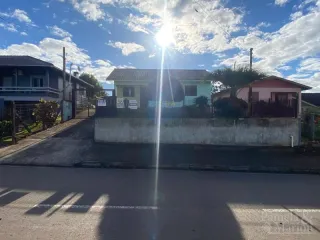 Fachada de uma casa residencial em Lajeado, Brasil, com muro frontal e vegetação.