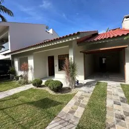 Fachada de uma residência com paisagismo e entrada coberta.