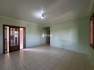Interior de uma sala com paredes verde-claro e piso de cerâmica clara.