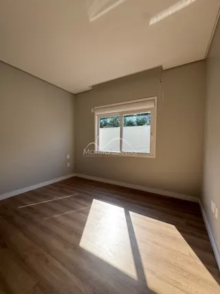 Sala de estar com piso de madeira e janela.