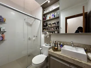 Foto de um banheiro moderno com box de vidro e bancada de mármore.