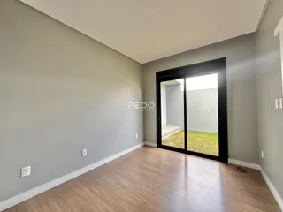 Vista interna de um ambiente com piso de madeira e paredes cinzas.