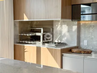 Cozinha moderna com armários de madeira e bancadas de mármore.