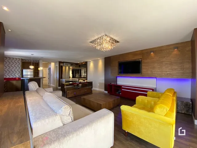Sala de estar ampla com sofás amarelos e painéis de madeira.