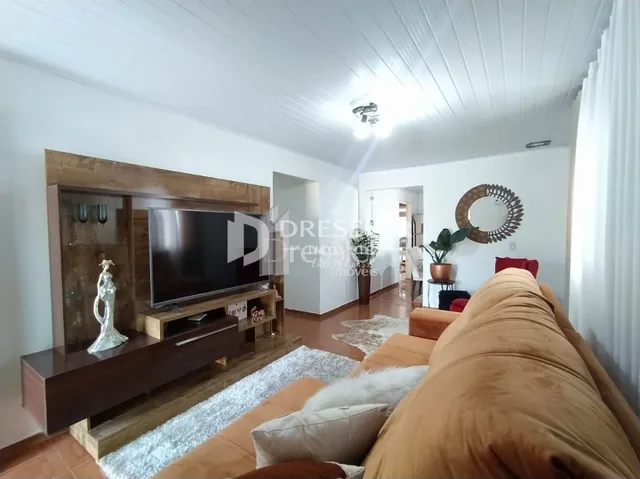 Sala de estar com sofá e televisão em ambiente claro.