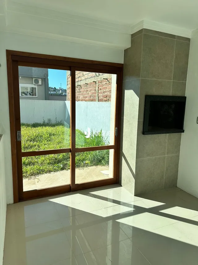 Sala de estar com porta de vidro que dá acesso ao jardim.