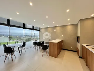 Ambiente interno de uma sala de jantar com vista para o exterior.