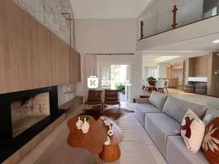 Sala de estar moderna com lareira e sofá grande em um apartamento.
