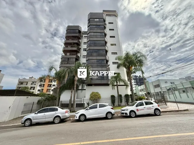 Fachada de um prédio residencial moderno em Lajeado, Brasil, com apartamentos e estacionamento na rua.