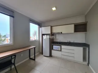 Interior de uma sala com janelas e piso claro.