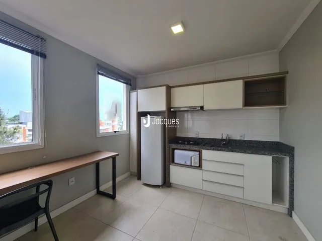 Interior de uma sala com janelas e piso claro.