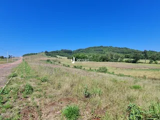 Vista de campo aberto com colinas verdes ao fundo