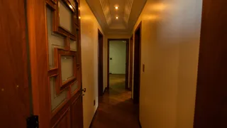 Corredor interno de uma residência com paredes e portas de madeira.