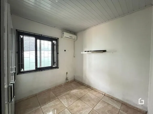 Interior de um cômodo com piso de cerâmica e janela.