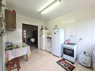 Foto de uma cozinha com armários brancos e piso de cerâmica clara.