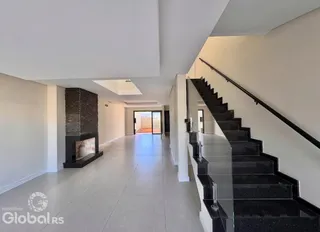 Hall de entrada com escadaria e lareira em um imóvel.