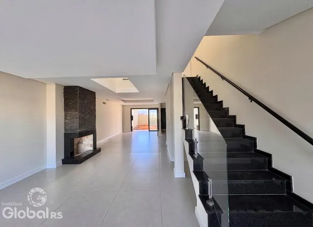 Hall de entrada com escadaria e lareira em um imóvel.