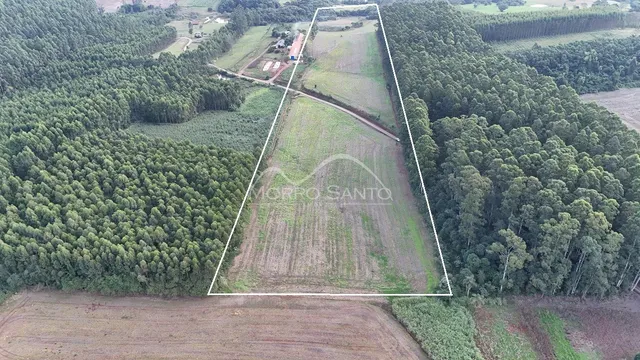 Vista aérea de uma área de terreno com vegetação e campos.