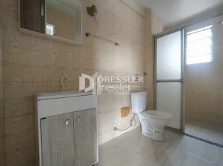Foto de um banheiro interno com azulejos claros e vaso sanitário branco.