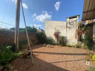 Vista da fachada de uma propriedade com muro de tijolos e jardim na Lajeado.