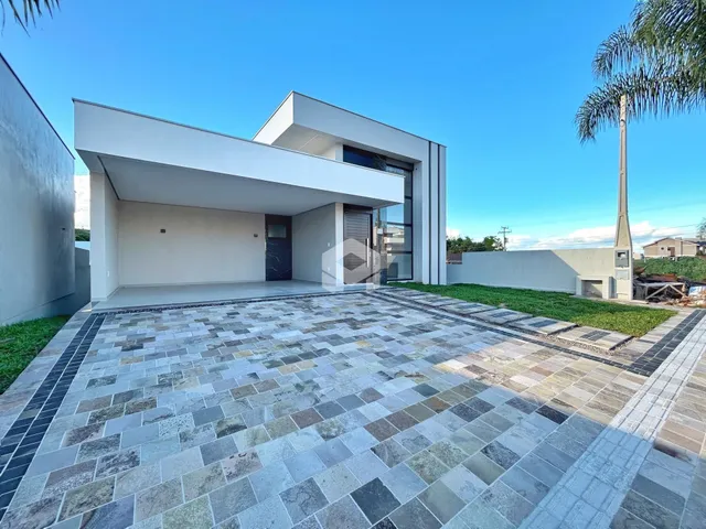 Fachada moderna de uma residência com área externa pavimentada em Lajeado.