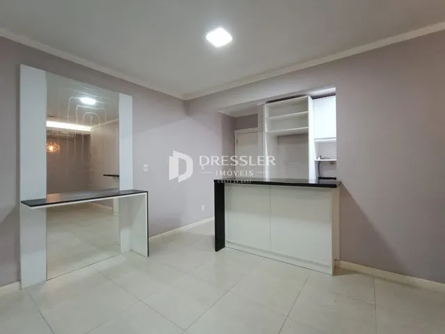 Interior de um corredor com piso de cerâmica e espelho.