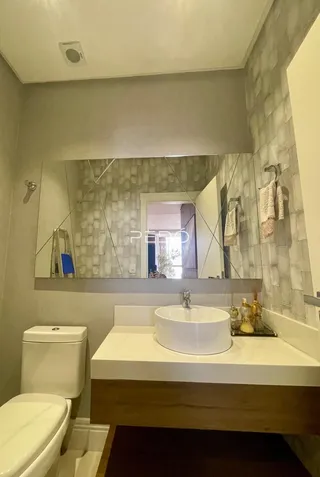 Foto de um banheiro moderno com revestimento de parede e bancada branca.