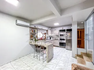 Cozinha moderna com ilha e eletrodomésticos em um imóvel em Lajeado.