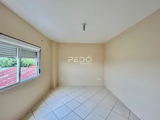 Vista interna de um cômodo com piso de cerâmica e janela.