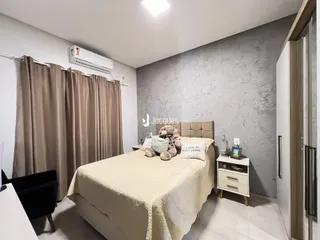 Quarto com cama e cortinas de cor bege.