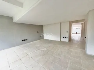 Vista interna de um corredor amplo com piso de cerâmica clara.