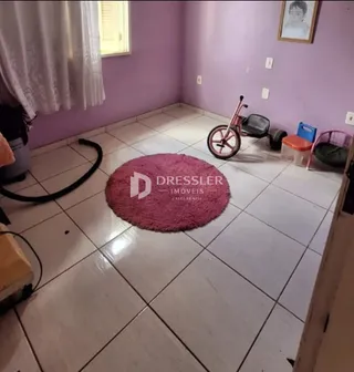 Foto de uma sala com piso de cerâmica clara e tapete no centro.