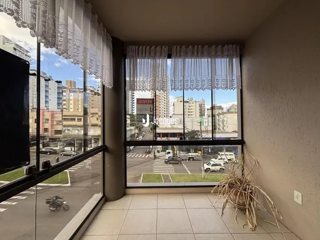 Sala de estar com vista para a rua através de grandes janelas.
