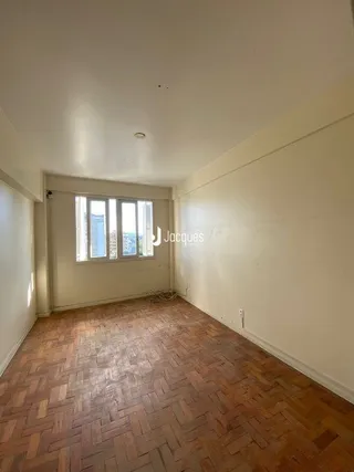 Sala com piso de madeira e paredes claras.