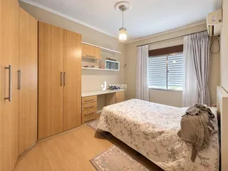 Quarto com armários de madeira e janela.