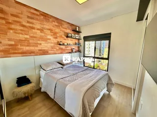 Quarto com cama de casal e parede de tijolos aparentes.