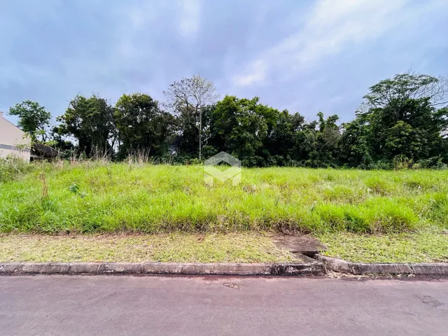 Campo de grama verde com árvores ao fundo.