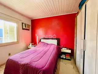 Quarto com parede vermelha e janela em um imóvel no Brasil.