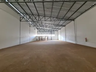Foto de um espaço interno vazio com estrutura de teto de metal exposta.