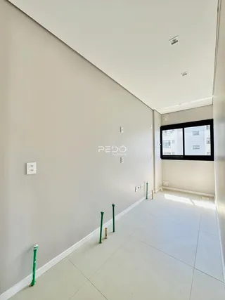 Hall de entrada com paredes brancas e piso claro.