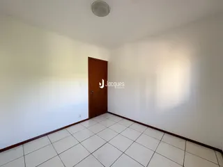 Interior de um cômodo com piso de cerâmica branca e paredes brancas.