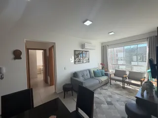 Sala de estar com sofá e janela em um apartamento no Brasil.