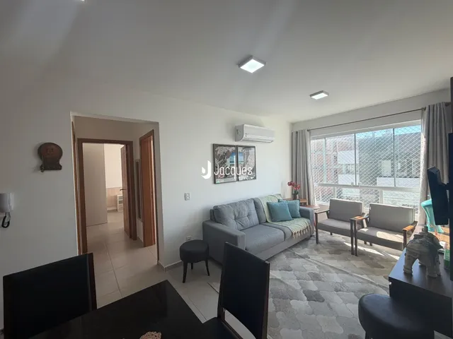 Sala de estar com sofá e janela em um apartamento no Brasil.
