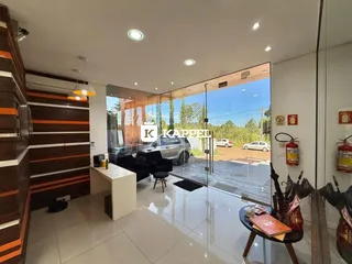 Sala de estar com piso claro e grandes portas de vidro que dão para o exterior.