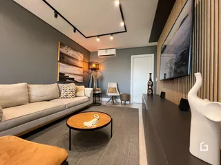 Sala de estar moderna com sofá e decoração em um apartamento.
