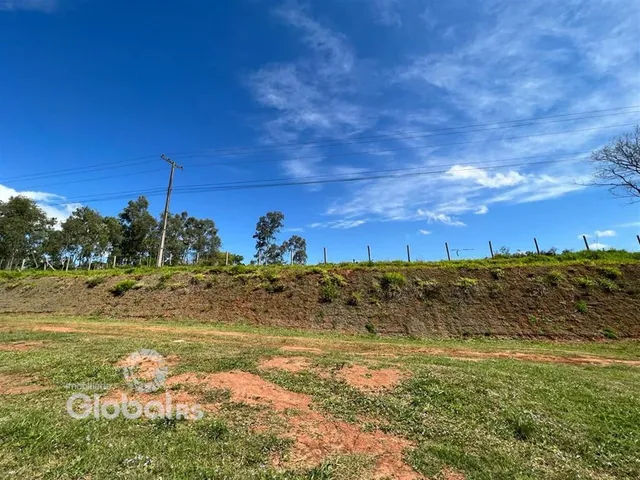 Vista panorâmica de uma área de terra com vegetação e céu azul.