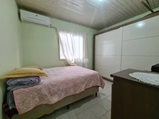 Quarto interno com cama e janela em uma residência.