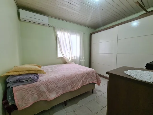 Quarto interno com cama e janela em uma residência.