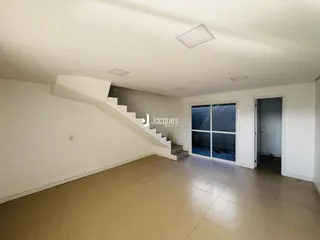 Ambiente interno de uma sala com escadaria e porta de vidro.