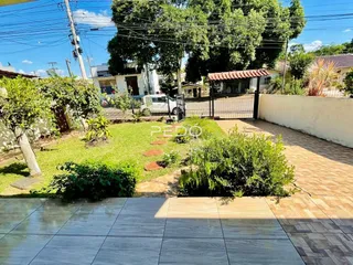 Vista externa de um quintal com gramado e muro branco em Lajeado.